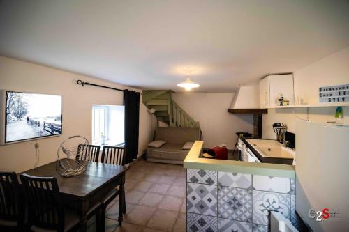 a kitchen and dining room with a table and a kitchen and a room at À la campagne in Cezay