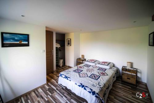 a bedroom with a bed with a quilt on it at À la campagne in Cezay