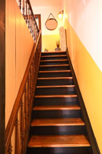 a set of stairs in a hallway with yellow walls at Un étage entier dans une maison in Hinsbourg