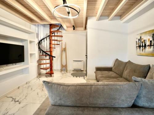 a living room with a couch and a tv at Anna's Corfu Escape Apartments 1 in Agios Ioannis