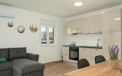 a kitchen and living room with a couch and a table at Number One Apartments in Vir
