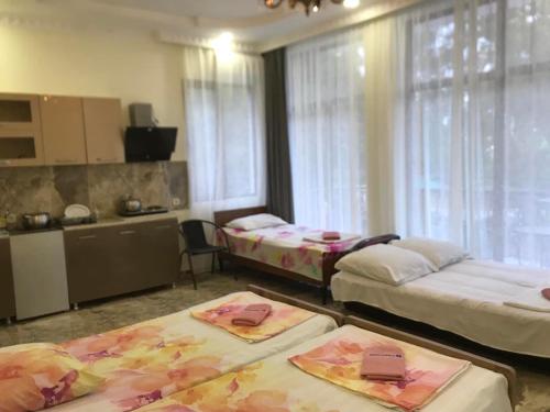 una camera con due letti e una cucina con finestre di THEODORE-Hotel a Kobuleti