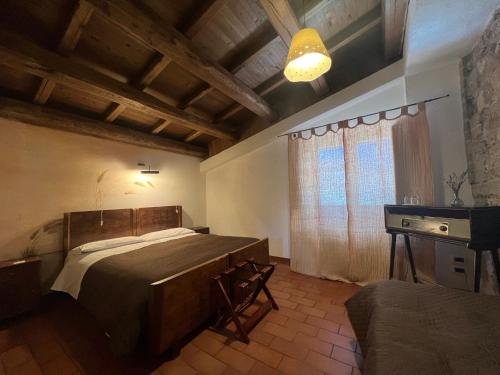 a bedroom with a bed and a desk and a window at Locanda Sul Lago in Santo Stefano di Sessanio