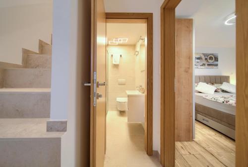 a bathroom with a sink and a toilet and a bed at Apartment Veris in Vrbnik