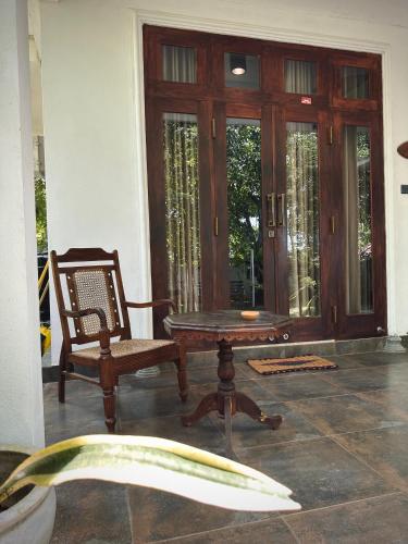 a room with a table and a chair and a door at Bananas Palm Villa in Mirissa
