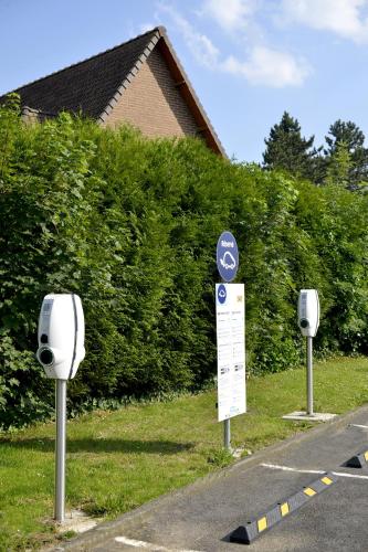 three parking meters on the side of a road at Premiere Classe Arras - Tilloy Les Mofflaine in Tilloy-lès-Mofflaines