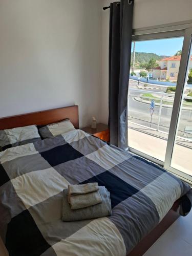 a bedroom with a bed with a large window at G at Bela Baia Salir in Salir de Porto