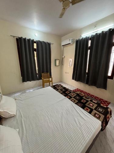 a large bed in a bedroom with black curtains at Pipewalas house in Varanasi