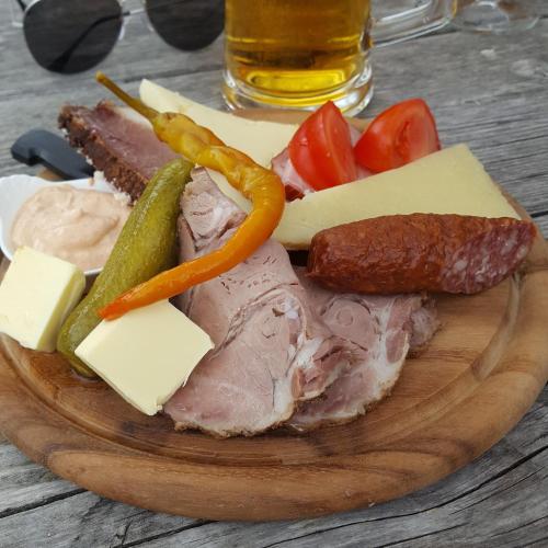 a plate of food with meat cheese and vegetables at Van der Molen in Innerkrems