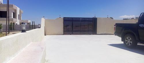 a car parked in front of a fence with a gate at مزرعة فراس الحوامدة 