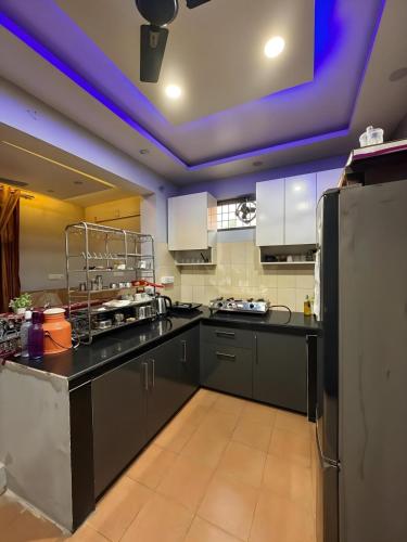 a kitchen with black counters and a purple ceiling at Waterfront Homestay 2BHK Free Bonfire By Homeyhuts in Mandi