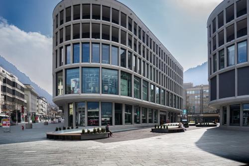 a large building with many windows in a city at Zentral Altstadt Chur - Bahnhofsnah - Ferienwohnung - Bernina Express - Solution-Grischun in Chur