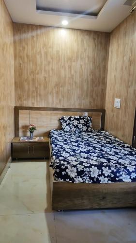 a bedroom with a bed and a wooden wall at Waterfront Homestay 2BHK Free Bonfire By Homeyhuts in Mandi