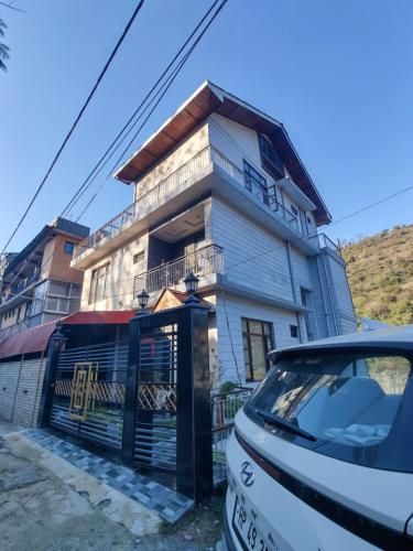 a house with a car parked in front of it at Waterfront Homestay 2BHK Free Bonfire By Homeyhuts in Mandi