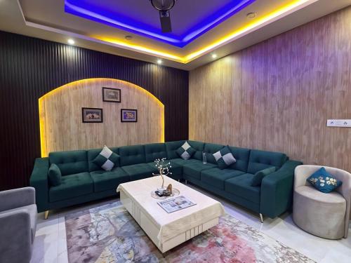 a living room with a green couch and a table at Waterfront Homestay 2BHK Free Bonfire By Homeyhuts in Mandi