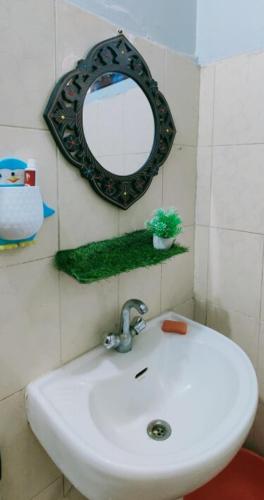 a bathroom with a sink and a mirror on the wall at Waterfront Homestay 2BHK Free Bonfire By Homeyhuts in Mandi