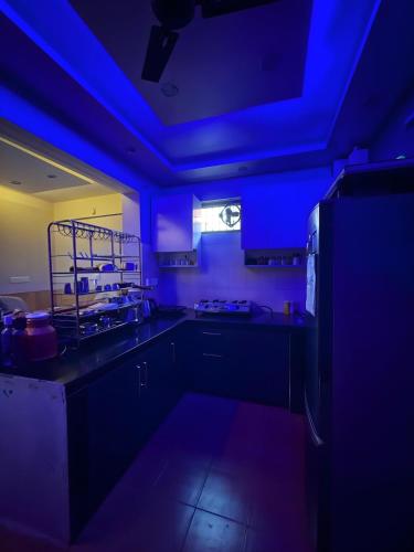 a kitchen with blue lights in a dark room at Waterfront Homestay 2BHK Free Bonfire By Homeyhuts in Mandi