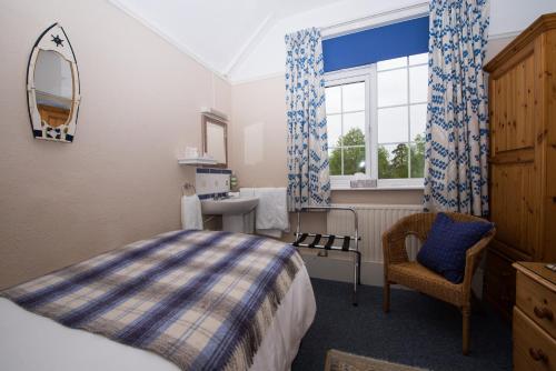 a bedroom with a bed and a chair and a window at The Maples in Hythe