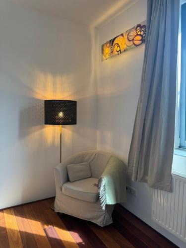 a living room with a chair and a lamp at Ferienwohnung Faulhauer in Welschbillig
