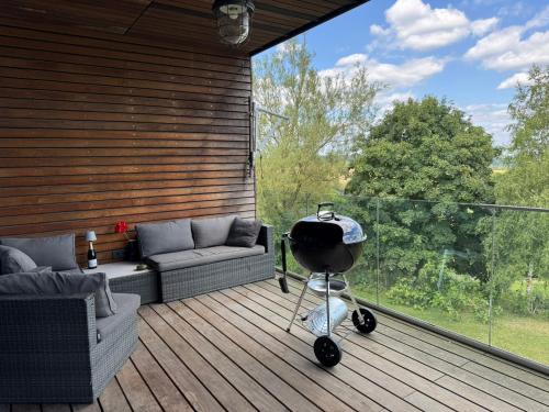 a grill on the deck of a house at Ferienwohnung Faulhauer in Welschbillig