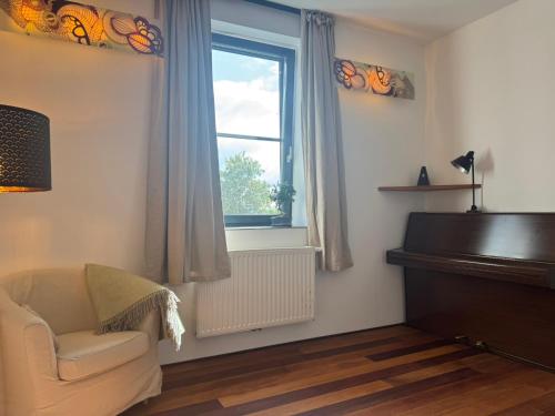 a living room with a chair and a piano at Ferienwohnung Faulhauer in Welschbillig