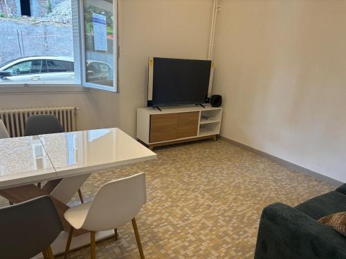 een woonkamer met een tafel en een tv bij Appartement entier in Aubenas