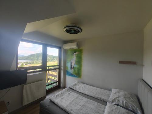 a bedroom with a bed and a window with a bird on the wall at Noclegi nad Soliną in Solina