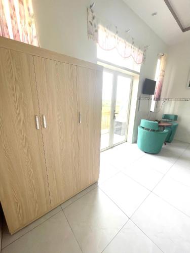 a room with a large wooden cabinet and a large window at HALA Hotel in Long An