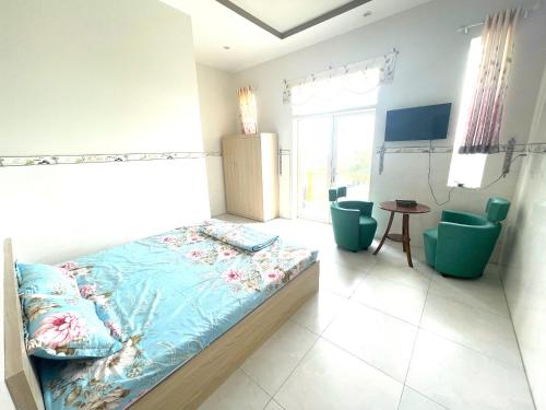 a bedroom with a bed and two chairs in it at HALA Hotel in Long An