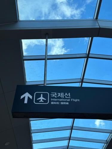 a sign in an airport with the sky in the background at Gate303 in Seoul