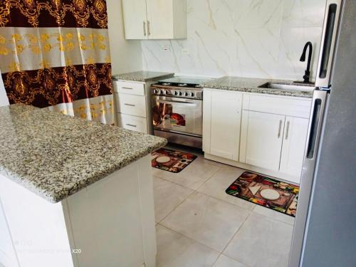 a kitchen with white cabinets and a stainless steel refrigerator at Casa Quiet in Black River
