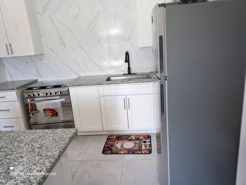 a white kitchen with a sink and a refrigerator at Casa Quiet in Black River