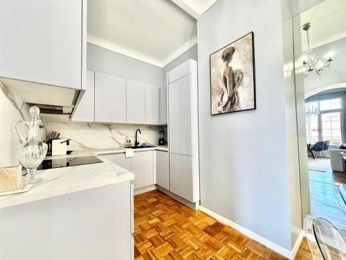 une cuisine avec des armoires blanches et un plancher en bois dans l'établissement Luxury apartment near MonteCarlo, à Beausoleil