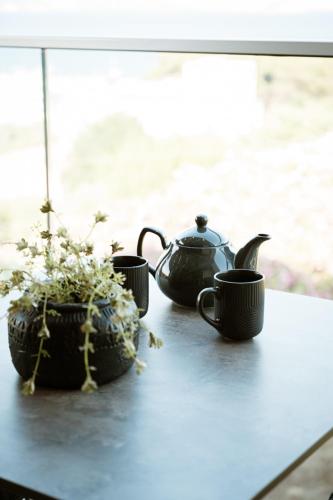 a table with three tea cups and a potted plant at Zante Sun Resort in Lithakia