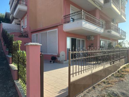 a pink house with a fence in front of it at Sky studio in Nea Kalikratia