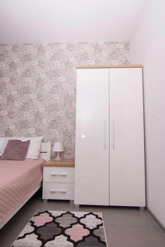 a bedroom with a white cabinet and a bed and a rug at WILLA DobraNocka in Szklarska Poręba