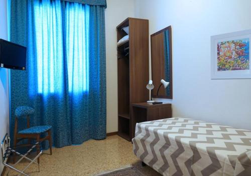 a bedroom with a bed and a blue curtain at Locanda Al Santuario in Peschiera del Garda