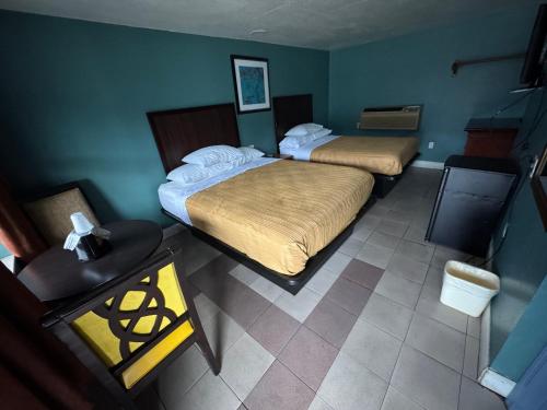 a hotel room with two beds and a table at Budget Motel in Orlando