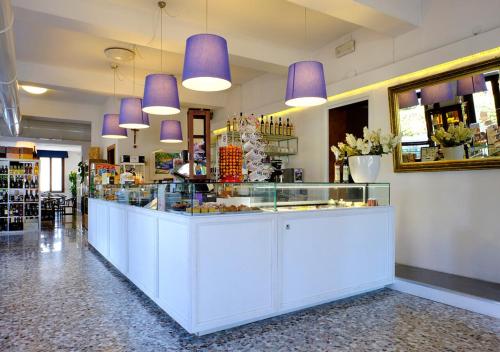 a restaurant with a counter with purple pendant lights at Locanda Al Santuario in Peschiera del Garda