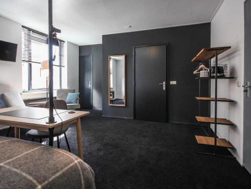 a room with a bed and a desk and a table at Boutique Hotel Pake Klaas in Sneek