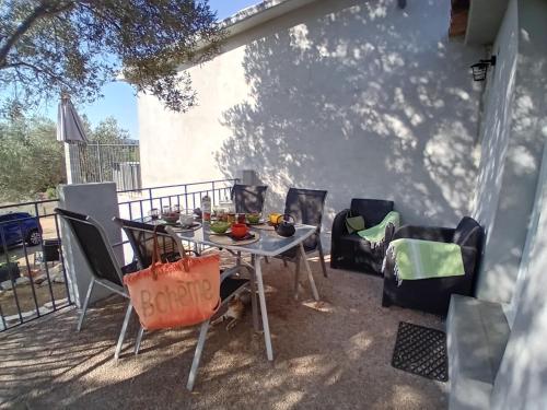 a table and chairs sitting on a patio at La maison sous les oliviers Casa d'Iloa in Porto-Vecchio