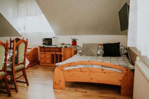 a bedroom with a wooden bed and a kitchen at Willa Murena in Mielno