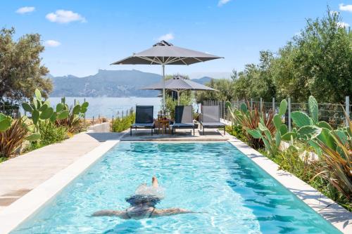 a man swimming in a swimming pool in a house at blue symphony suites and apartments in Nikiana
