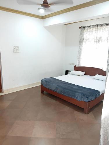a bedroom with a bed in a white room at Bright Beach Homestays in Calangute