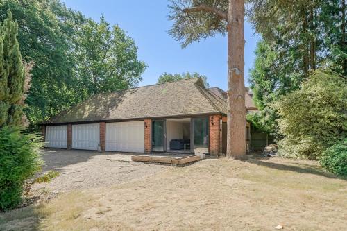 a house with a tree in front of it at Chalet Gerrards Cross in Gerrards Cross