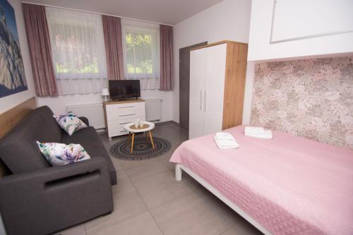 a bedroom with a pink bed and a chair at WILLA DobraNocka in Szklarska Poręba