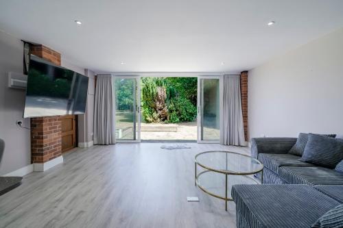 a living room with a couch and a tv at Chalet Gerrards Cross in Gerrards Cross
