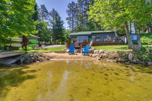 a house with a pond in front of it at Pequot Lakes Cabin with Dock on Loon Lake! in Pequot Lakes