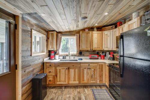 a kitchen with wooden cabinets and a black refrigerator at Pequot Lakes Cabin with Dock on Loon Lake! in Pequot Lakes