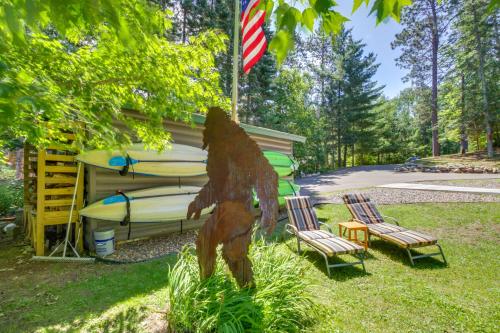 a statue of a bear next to two chairs and a house at Pequot Lakes Cabin with Dock on Loon Lake! in Pequot Lakes